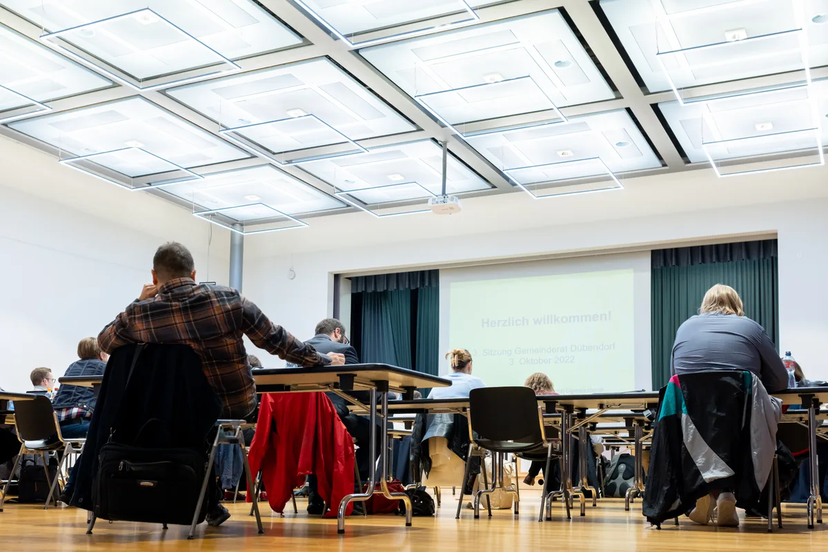 Mehrere Personen sitzen in einem Raum.